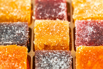 A close up of a tray of assorted marmalade colored candies