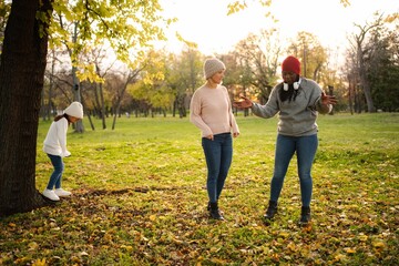 Diverse adult women and child talking in autumn park