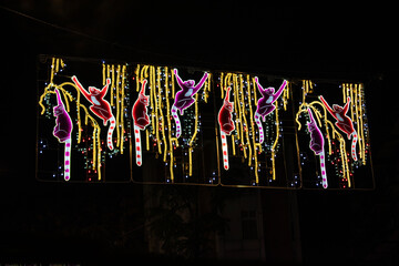 Yellow Christmas lights with lemur figures on a street in Madrid, Spain.