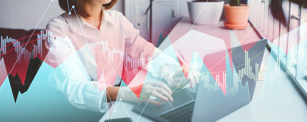 Businesswoman is seated at a table in a modern coworking space, absorbed in her laptop. She contemplates workplace challenges and navigates online tasks in a stylish environment.