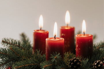 Warm candle lights with evergreen branches, creating a festive and serene atmosphere.