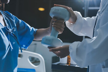 Physical therapist assisting a woman with dumbbell exercise