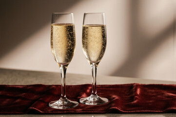 Two flutes of champagne with effervescent bubbles on a rich red velvet cloth, symbolizing luxury and celebration.