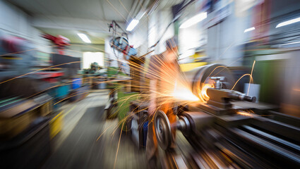a factory workshop where a lathe is operating and sparks are flying from it