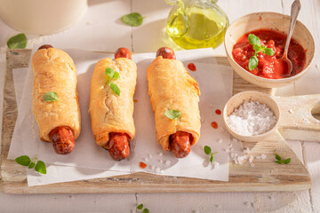 Unhealthy hot dogs with herbs and tomato sauce.
