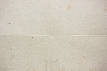 Vintage folded paper texture with visible crease lines and subtle stains, aged surface background ideal for design projects, retro layouts, scrapbook materials and creative graphic applications