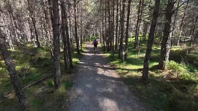 nice senior woman riding her electric mountain bike  in the highlands of Cairn Gorms National Park , Scotland, UK