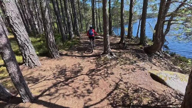 nice senior woman riding her electric mountain bike  in the highlands of Cairn Gorms National Park , Scotland, UK