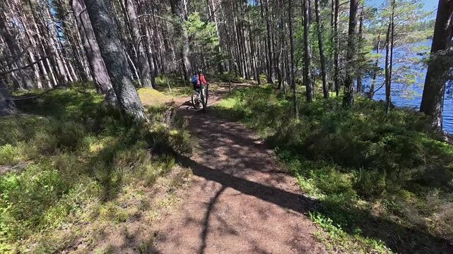 nice senior woman riding her electric mountain bike  in the highlands of Cairn Gorms National Park , Scotland, UK