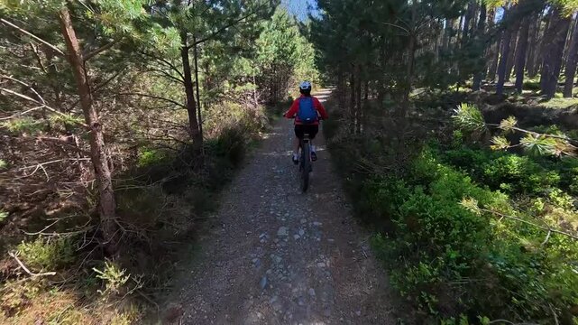  woman riding her electric mountain bike  in the highlands of Cairn Gorms National Park , Scotland, UK