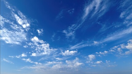 Obraz premium Bright blue sky filled with clouds of various shapes. The scene captures the open atmosphere during the daylight hours with few clouds in sight.