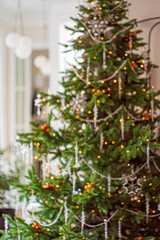 A cozy scene features a sparkling Christmas tree adorned with lights and ornaments