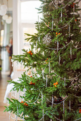 A lush holiday tree with sparkling ornaments brightens a warm, inviting room