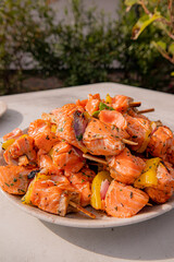 Fresh salmon pieces and bright peppers grilled to perfection, served in a lively outdoor garden