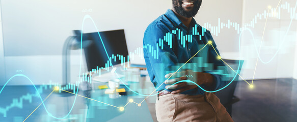 A business professional is smiling confidently while standing in a modern office. Financial graphics and data overlays highlight key market trends and statistics around the individual.
