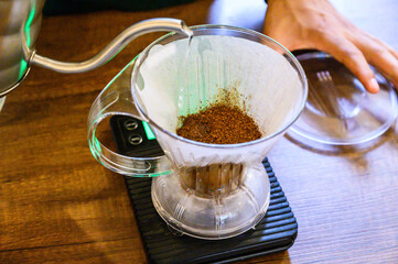 Barista preparing pour over coffee brewing fragrant grounds