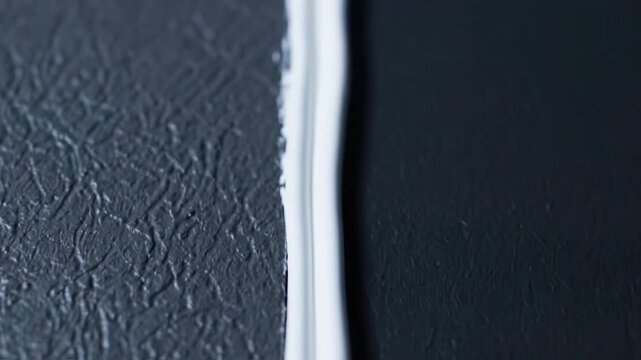 Abstract macro view of white object and textured dark surface