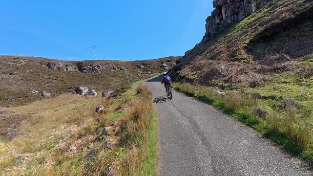 active senior woman riding her electric mountain bike on the moor landscape  of Rua Reidh point  near Gairloch  in Scotland, UK