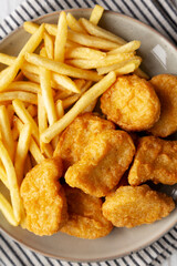 Chicken Nuggets with French Fries on a Plate, top view.