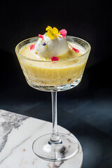 Colorful dessert features creamy texture, topped with ice cream and vibrant edible flowers