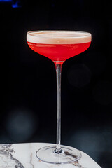 A stunning red cocktail on a marble table invites enjoyment and conversation