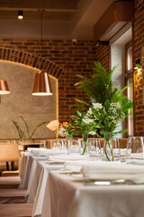 Tables are beautifully arranged with fresh flowers, creating a cozy and inviting dining atmosphere