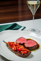 Delicious lamb tenderloin served with fresh tomatoes and a glass of fine white wine