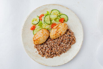 Delights of seasoned meatballs paired with bulgur wheat and a crisp salad of cucumbers and tomatoes