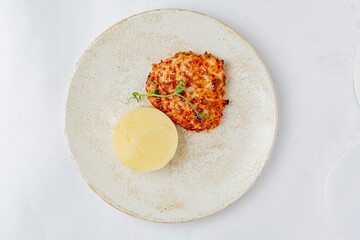 Savory baked dish is paired with smooth, creamy side on an elegant plate, ideal for special meals