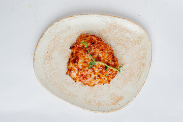 Enjoy a cheesy, golden creation topped with fresh herbs on a rustic plate
