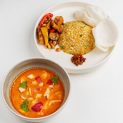 A vibrant array of dishes features rich curry, fragrant rice, chicken, and crispy chips