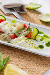 Vibrant salad featuring creamy burrata, fresh vegetables, and drizzled with green sauce