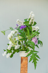 Colorful flowers burst from a simple vase, celebrating the joy of nature and creativity