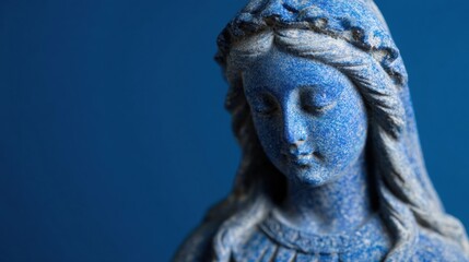 Statue of a woman in blue stone with a solid color background