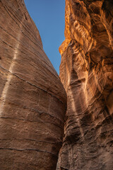 Vertical Red Sandstone Cliff with Blue Sky in Jordan. Rock Formation in Petra. Rocky Texture in the Middle East.