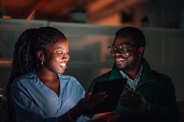 Black couple sharing digital tablet feeling happy