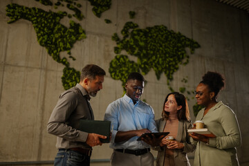 Diverse business team collaborating in eco friendly office lobby
