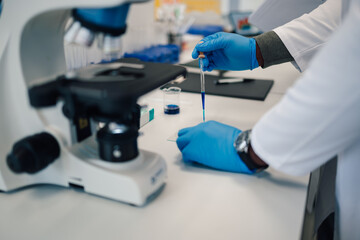 Scientist hands working with microscope in laboratory
