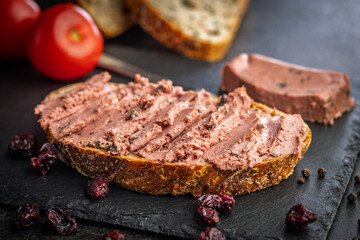 Pate on a slice of bread on black table.