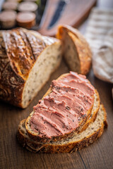 Pate on a slice of bread on wooden table.