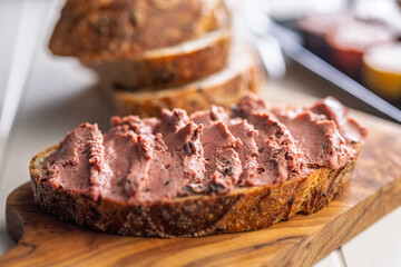 Pate on a slice of bread on white table.