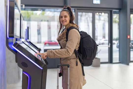 Woman using self-service kiosk for digital check-in