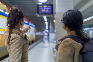 Women discussing train information on station platform