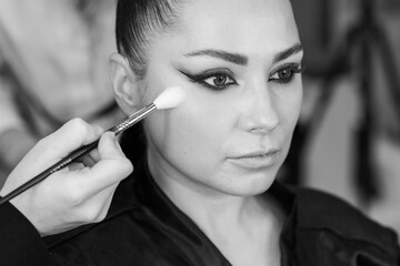 Elegant actress preparing for an important role while getting professional makeup and hairstyling in a beauty salon