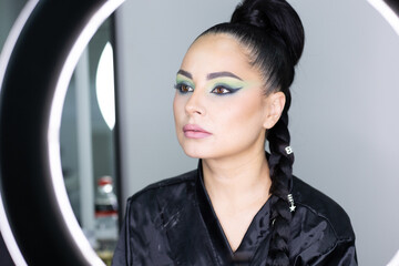 Elegant actress preparing for an important role while getting professional makeup and hairstyling in a beauty salon