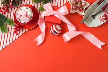 Merry Christmas and New Year background with bow, gift box, marshmallow and decorations. Top view, flat lay