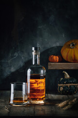 Glass and bottle of whiskey on a wooden table
