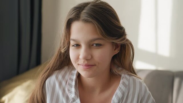 White Teenage Girl Sitting On Couch, Soft Morning Sunlight And Striped Pajamas, Relaxed Gaze And Faint Smile, Window Light And Curtain Shadows, Candid Closeup Capturing Natural Beauty And Cozy Home