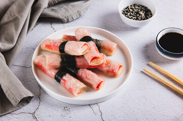 Fried spring rolls with crab sticks and nori on a plate on the table