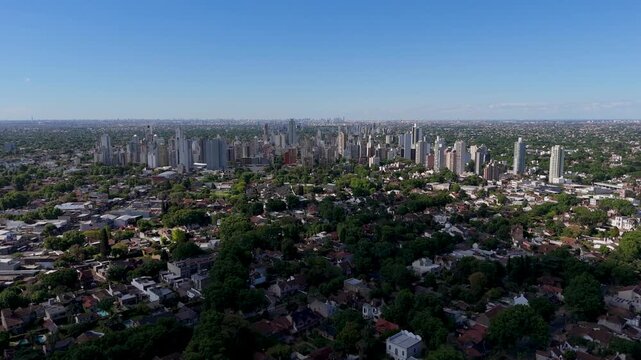 Vista a&eacute;rea con drone del centro de Lomas de Zamora y la Avenida Hip&oacute;lito Yrigoyen con Lan&uacute;s y el skyline de Puerto Madero de fondo. Buenos Aires, Argentina